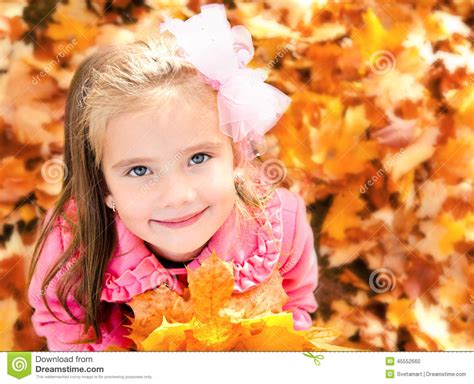 Autumn Portrait Of Adorable Little Girl With Maple Leaves Stock Photo