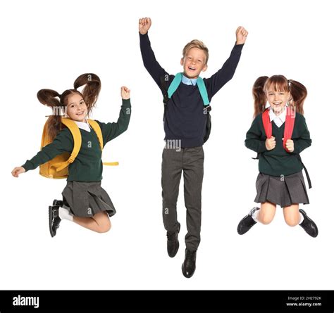 Cute School Children In Uniform With Backpacks Jumping On White