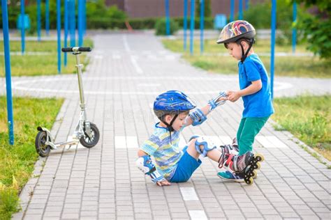 Girl Park Helps Boy Roller Skates To Stand Up Stock Photos Free