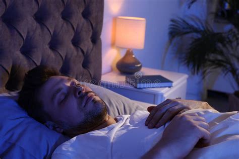 Handsome Man Sleeping On Pillow In Dark Room At Night Stock Image