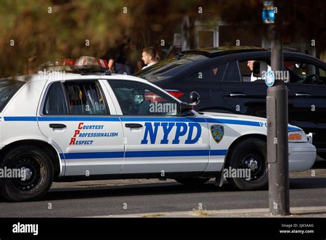 A Vintage Nypd Ford Crown Victoria Sedan Car Driving On An English