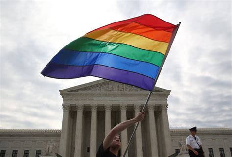 A Supporter Of Same Sex Marriage Waving A Rainbow Colored Flag Outside