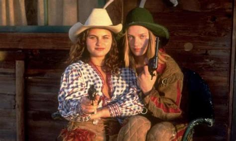 two women dressed in western style clothing sitting on a chair with their arms around each other