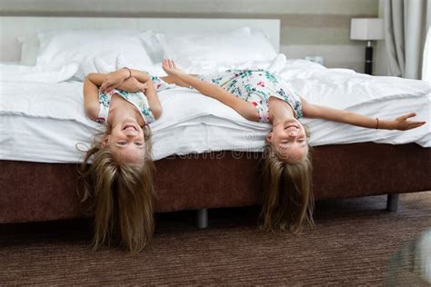 two twin sisters are lying on the bed upside down stock image image of little cheerful 263182709