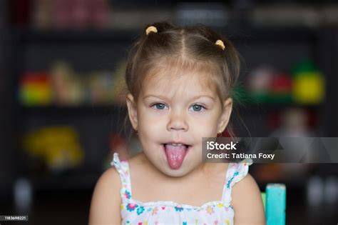 Potret Gadis Kecil Lucu Potret Gadis Kecil Lucu Yang Menunjukkan Lidah Menatap Kamera Foto Stok