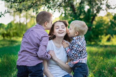 Hijos Pequeños Besan A Mamá En La Mejilla Madre Feliz Con Dos Niños En