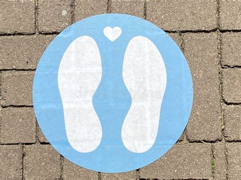 Close Up Of Isolated Blue Marking Sign With Feet On The Floor To Wait