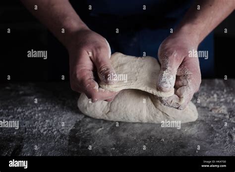 Baker examining dough Stock Photo - Alamy
