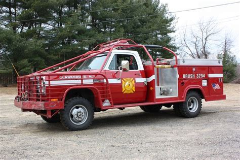 A Red Fire Truck Parked On Top Of A Dirt Field