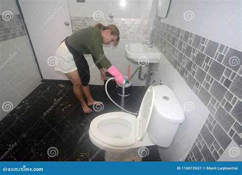 Asian Female Maid Or Housekeeper Cleaning Spray Water On Floor Stock