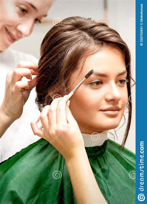 Makeup Artist Combing Eyebrows And Hairstylist Preparing Hairstyle
