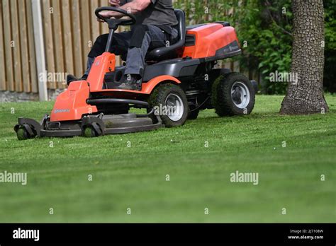 A Man Mowing A Lawn On A Ride On Mower On A Spring Day Stock Photo Alamy