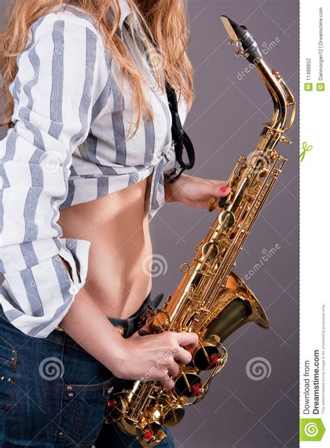 stomaco di giovane ragazza bionda sexy con il sassofono fotografia