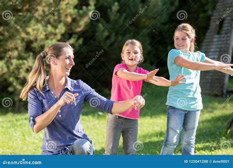 Mother With Children Daughters Doing Dance Exercise Outdoors Stock