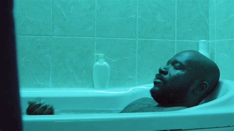 African American Man Relaxing In Water While Taking Bath In Evening At