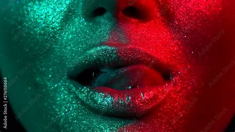 sexy woman licking lips in bright sparkles colorful neon lights trendy glowing gold skin