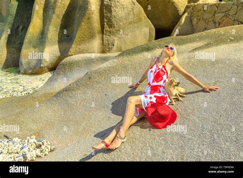 Attractive Blonde Lifestyle Woman With A Cute Dog Sunbathing On A