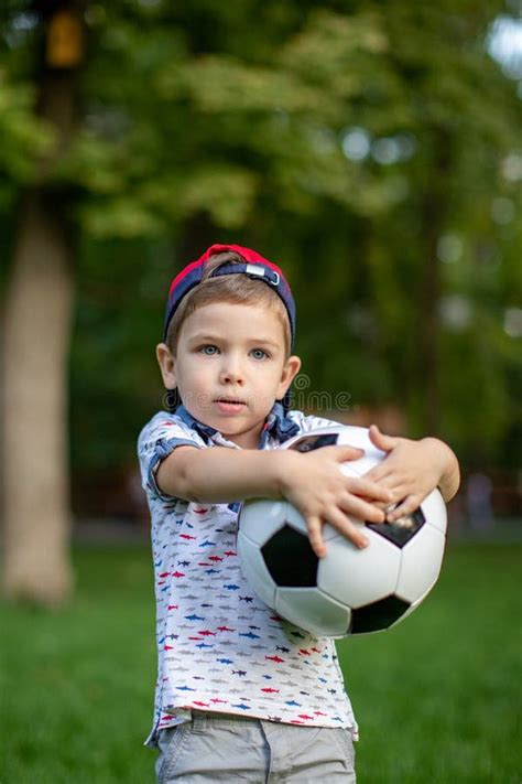 Little Child Hand Holding Football And Playing Soccer Ball Stock Image
