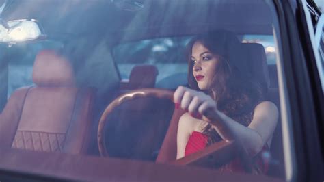 A Woman With Evening Make Up And In A Beautiful Dress Sits At The Wheel
