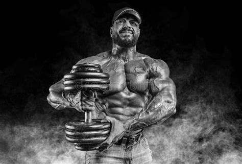 Muscular Athlete Posing In The Studio With Dumbbells Fitness And