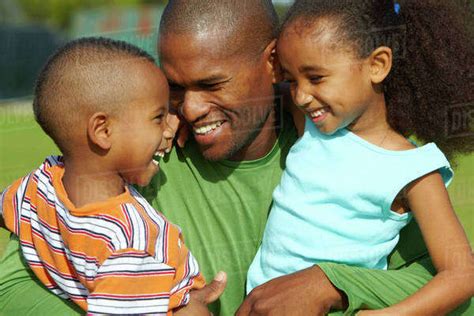 African American Father Hugging Son And Daughter Stock Photo Dissolve