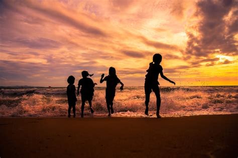 Premium Photo Silhouette Children Group Enjoy Playing Sea Waves On