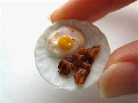 An Egg In A Shell With Bacon On It Is Being Held By Someones Hand
