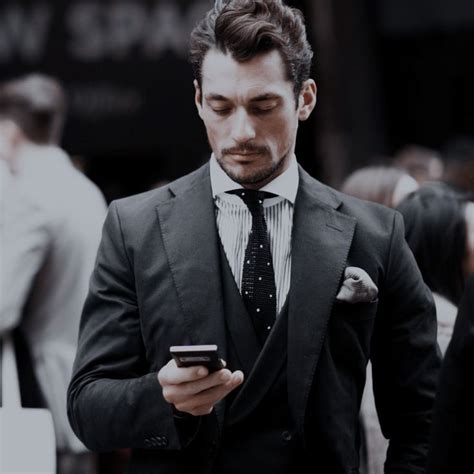 A Man In A Suit Looking At His Cell Phone