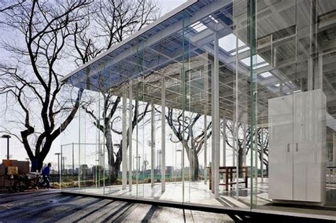A Glass Building With Trees In The Background