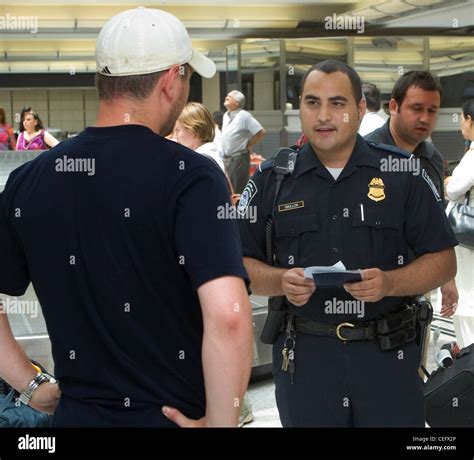 A Cbp Officer Checks A Passengers Document After Arriving At Dulles