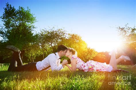 Romantic Couple In Love Kissing While Lying On Grass Photograph By