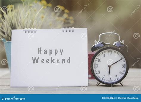 Happy Weekend Note on Morning Sunlight with Alarm Clock Stock Photo