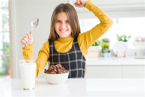 Beautiful Young Girl Kid Eating Chocolate Cereals And Glass Of Milk For