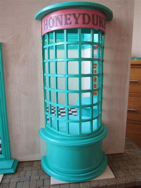 A Blue Phone Booth Sitting On Top Of A Brick Floor Next To A Dresser