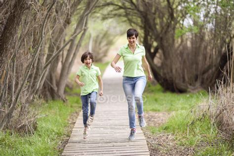 Happy Mother And Daughter Running On Boardwalk — Caucasian Energy
