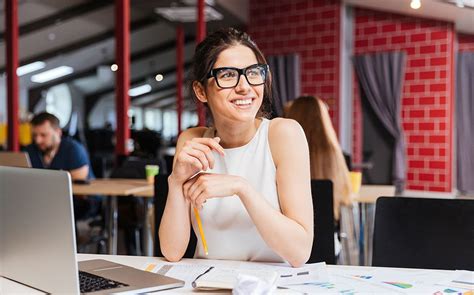 A Female Intern Smiles At Her Desk Business Woman Successful