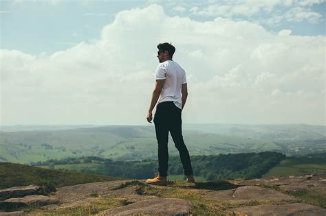 Man Standing On Bolder Overlooking The Hills And Mountains Hd