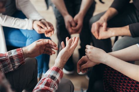 Close Up Of Hands Of People Sitting In A Circle During A Therapy Group