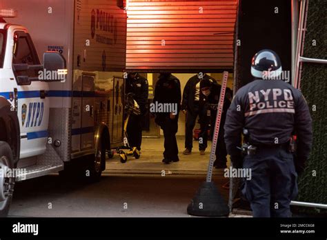 New York Police Department Officers Carry A Stretcher Into An Ambulance After Delivering The