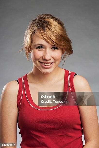 Teenage Girl In Red Tank Top Smiling Against Gray Background Stock