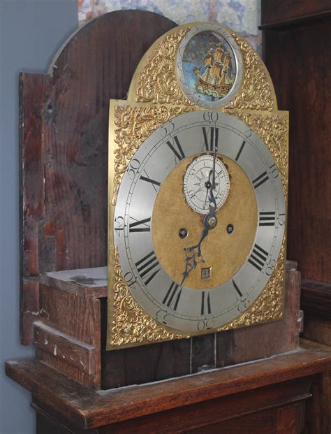 A Georgian Oak Eight Day Longcase Clock The Hood With Arched Top Three Brass Finials And Brass