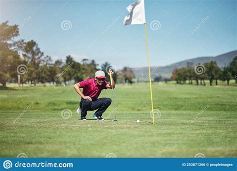 Why Wont You Go In A Focused Young Male Golfer Looking At A Golf Ball While Being Seated On The