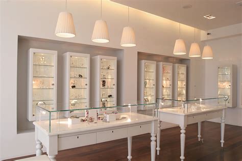 The Inside Of A Jewelry Store With Glass Shelves And Lights Above Them