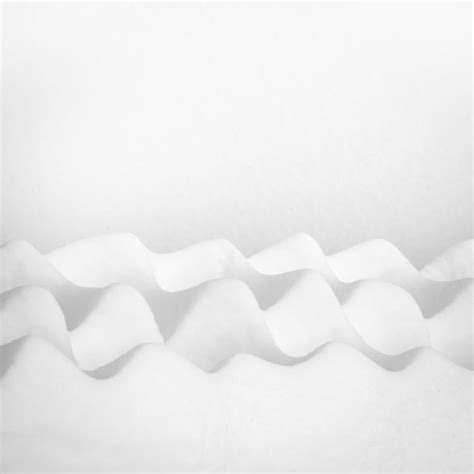 A Black And White Photo Of Snow On The Side Of A Building With Wavy Lines