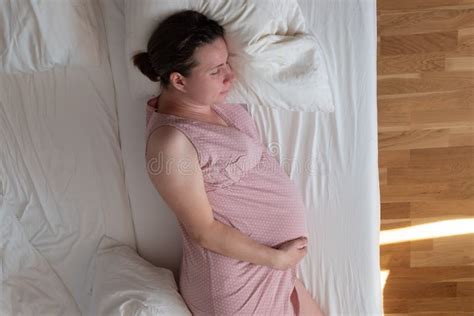 Pregnant Caucasian Mature Woman Sleeping In Bed At Home Stock Image