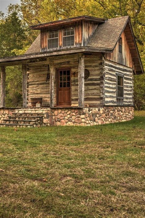 An Old Log Cabin Sits In The Grass