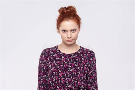 sad upset ginger woman looking at camera with unhappy facial expression being in bad mood