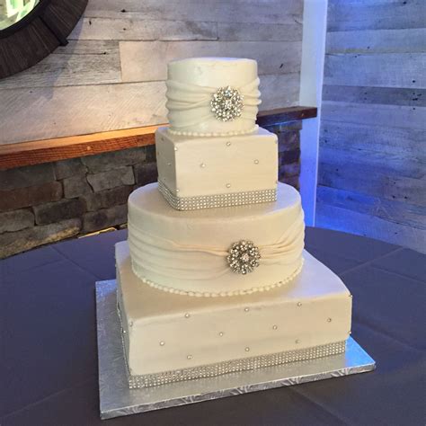 Roll out the fondant to the size of your cake. 4 tier round and square white buttercream wedding cake with fondant sashes, brooches and bling ...