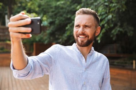 Premium Photo Cheerful Emotional Young Bearded Man Take A Selfie