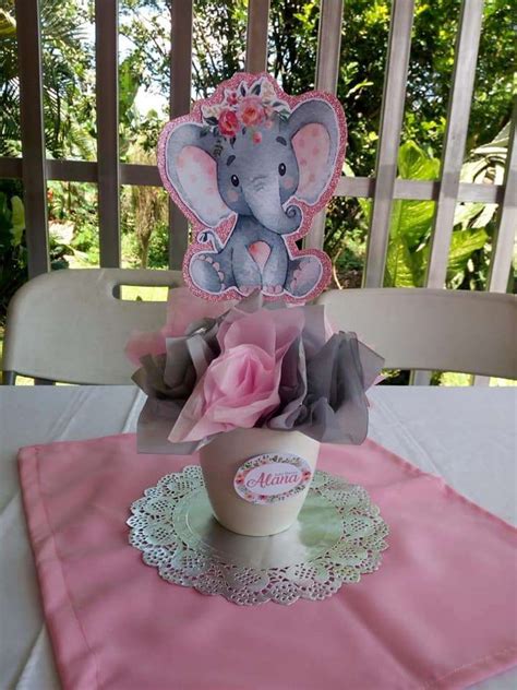 An Elephant Centerpiece On Top Of A Pink Table Cloth With A Cup And Saucer